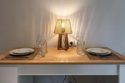 a table with a lamp and plates and glasses on it at 2b apartment beyond a house Glyfada center in Athens