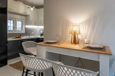 a kitchen with a table with chairs and a lamp at 2b apartment beyond a house Glyfada center in Athens