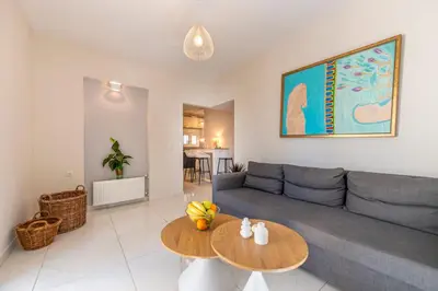 a living room with a blue couch and a table at 2b apartment beyond a house Glyfada center in Athens
