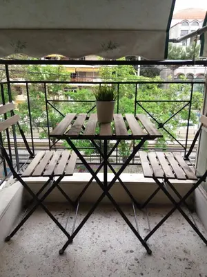 a table and a potted plant on a balcony at Apartments in Pereas in an ideal location in Piraeus