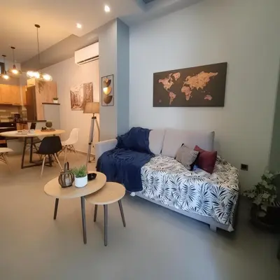 a living room with a blue couch and tables at Cozy Split-Level Loft by Piraeus Port in Piraeus