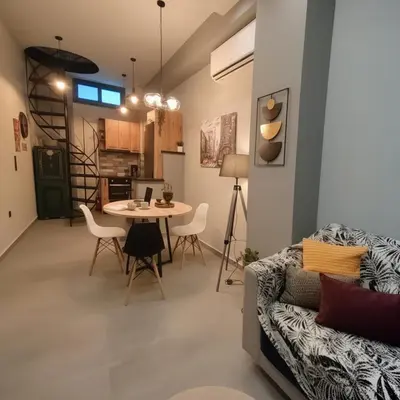 a living room with a couch and a table at Cozy Split-Level Loft by Piraeus Port in Piraeus