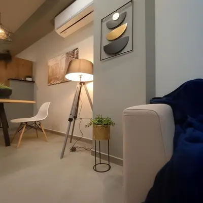 a living room with a lamp and a table at Cozy Split-Level Loft by Piraeus Port in Piraeus