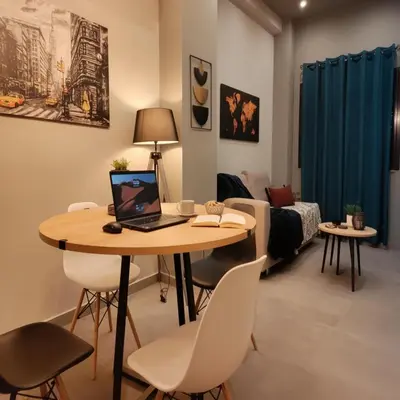 a room with a table with a laptop on it at Cozy Split-Level Loft by Piraeus Port in Piraeus