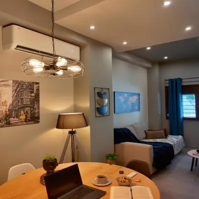 a living room with a table with a laptop on it at Cozy Split-Level Loft by Piraeus Port in Piraeus