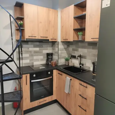 a kitchen with wooden cabinets and a sink and a stove at Cozy Split-Level Loft by Piraeus Port in Piraeus