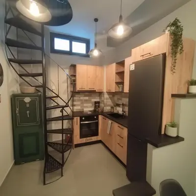 a kitchen with a spiral staircase in a kitchen at Cozy Split-Level Loft by Piraeus Port in Piraeus