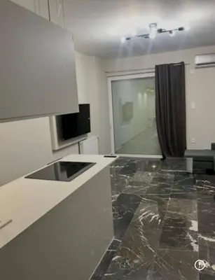 a kitchen with white counters and a tv and a window at Spacious 2-Bedroom Apartment in Paleo Faliro, Athens in Athens