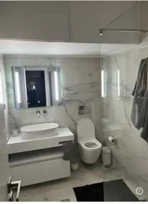 a bathroom with a sink toilet and a mirror at Spacious 2-Bedroom Apartment in Paleo Faliro, Athens in Athens
