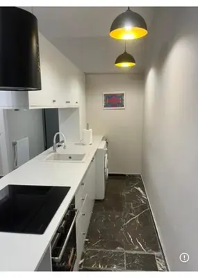 a white kitchen with a sink and a counter at Spacious 2-Bedroom Apartment in Paleo Faliro, Athens in Athens