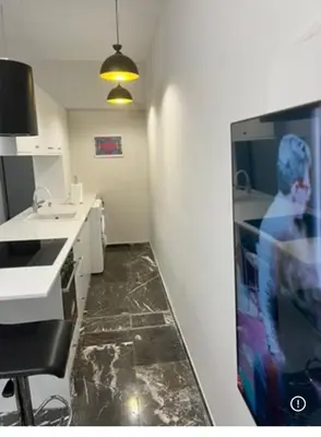 a kitchen with a tv on a wall in a room at Spacious 2-Bedroom Apartment in Paleo Faliro, Athens in Athens