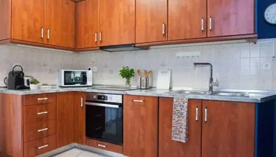 a kitchen with wooden cabinets and a sink and a microwave at Premium 2 Bd Blue Retreat in Kallithea in Athens