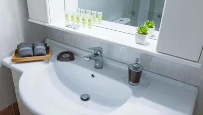 a bathroom with a sink with a mirror and towels at Premium 2 Bd Blue Retreat in Kallithea in Athens
