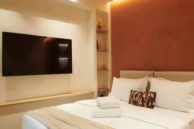 a bedroom with a bed with a flat screen tv on the wall at V13 Boho Suite in Athens