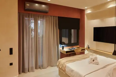 a hotel room with a bed and a flat screen tv at V13 Boho Suite in Athens