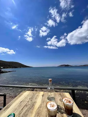 a table with two drinks and a bottle on it at Athens Riviera Villa overlooking the Aegean sea in Anavissos