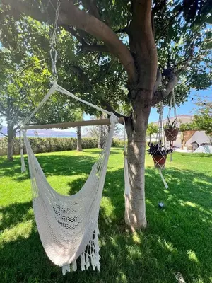 a white hammock hanging from a tree in a field at Athens Riviera Villa overlooking the Aegean sea in Anavissos