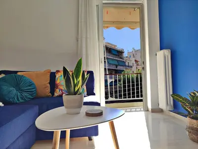 a living room with a blue couch and a table with a plant at Feels like home in Athens center in Athens