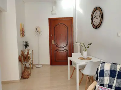 a living room with a table and a wooden door at Feels like home in Athens center in Athens