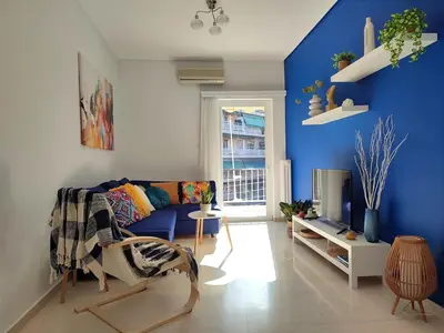 a blue living room with a couch and a tv at Feels like home in Athens center in Athens
