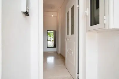 a hallway with a white door and a mirror at Cozy loft in the western suburbs of Athens! in Athens