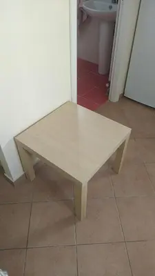 a wooden table sitting on top of a floor at Cozy loft in the western suburbs of Athens! in Athens