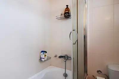 a bathroom with a shower and a bath tub at Cozy loft in the western suburbs of Athens! in Athens