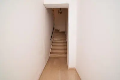 a hallway with a staircase with white walls and wooden floors at Cozy loft in the western suburbs of Athens! in Athens