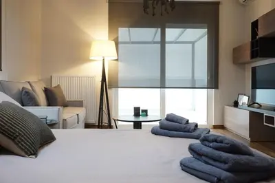 a bedroom with a white bed with blue towels on it at Athenean Rooftop Nest in Athens