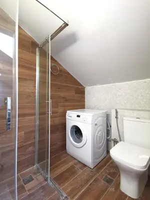 a bathroom with a washing machine and a toilet at Athenean Rooftop Nest in Athens