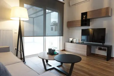 a living room with a couch and a table and a tv at Athenean Rooftop Nest in Athens