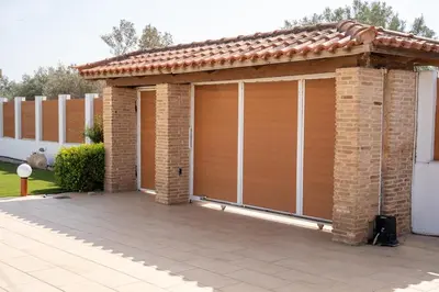 a wooden garage with a brick building at Villa Oneiron in Anavissos