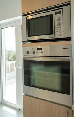 a microwave above a oven in a kitchen at Villa Oneiron in Anavissos