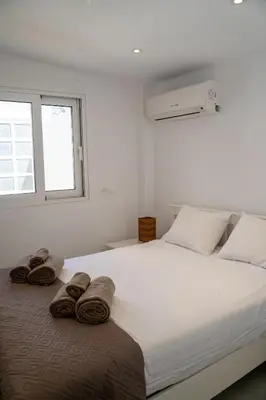 a bedroom with a large white bed with towels on it at Villa Oneiron in Anavissos