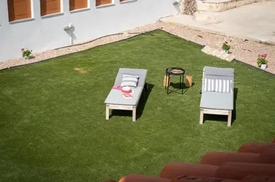 two chairs and a table on a grass field at Villa Oneiron in Anavissos