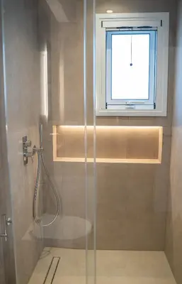 a bathroom with a shower with a window at Villa Oneiron in Anavissos