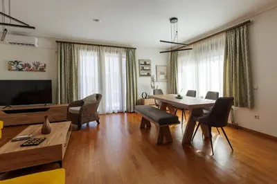 a large living room with a table and chairs at Villa Elysia in Porto Rafti