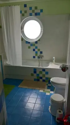 a bathroom with a tub and a toilet and a window at Pavlos apartment in Leondárion
