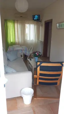 a living room with a white couch and a table at Pavlos apartment in Leondárion
