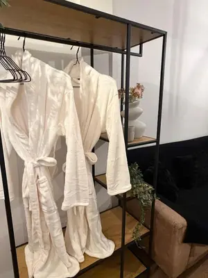a rack with white shirts on it in a room at Modern studio apartment in Athens