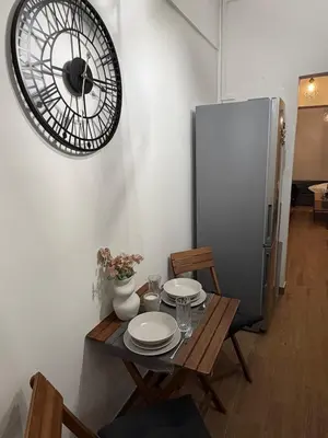 a table with plates and a refrigerator in a room at Modern studio apartment in Athens