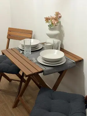 a wooden table with plates and a vase with flowers at Modern studio apartment in Athens