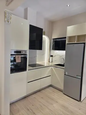 a kitchen with white cabinets and a refrigerator at 3siblings Β2 in Athens