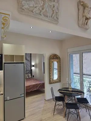 a living room with a table and a bed at 3siblings Β2 in Athens