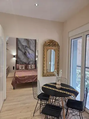 a room with a table and a bed with a mirror at 3siblings Β2 in Athens