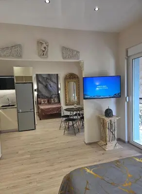 a room with a kitchen and a living room with a tv at 3siblings Β2 in Athens