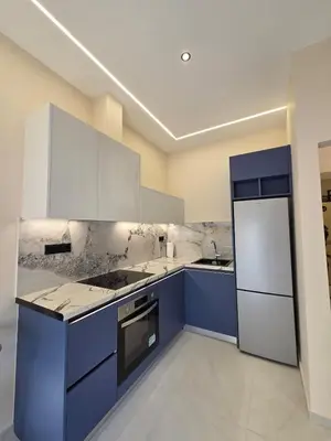 a kitchen with blue and white cabinets and appliances at 3siblings A2 in Athens