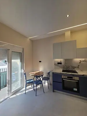 a kitchen with a table and chairs and a table and a stove at 3siblings A2 in Athens