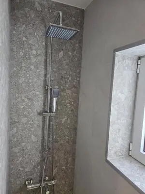 a shower in a bathroom next to a mirror at 3siblings A2 in Athens