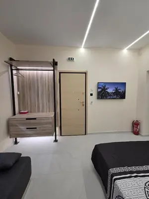 a bedroom with a bed and a dresser and a door at 3siblings A2 in Athens